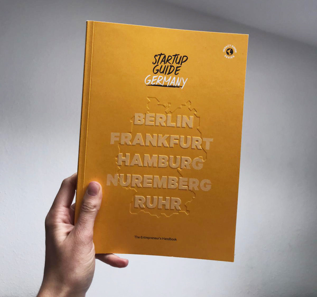 Start a business in Germany: Startup Guide Germany in einer Hand mit weißem Hintergrund